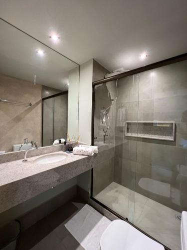 a bathroom with a shower and a sink and a mirror at Concept Studios Barrinha in Barra Grande