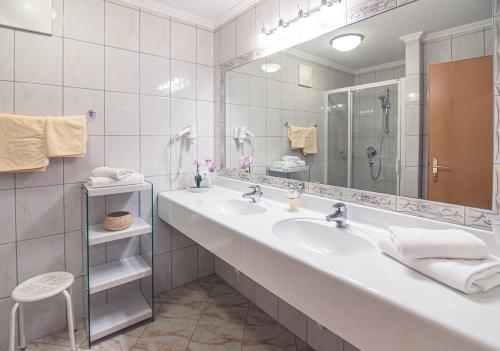 a bathroom with two sinks and a large mirror at Hotel Andrea 3-Sterne Superior in Gerlos
