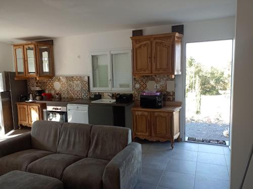 un salon avec un canapé et une cuisine dans l'établissement Location avec piscine Sud Ardèche, à Berrias Et Casteljau