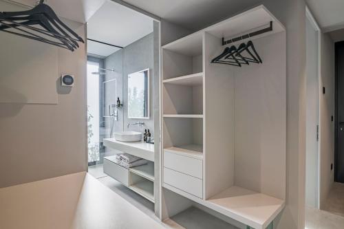 a white bathroom with a sink and a mirror at Agriturismo Insolito in Terlano