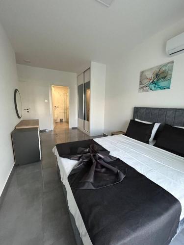 a bedroom with a large bed with a black blanket at Apartment Long Beach in Saint Yeorgios