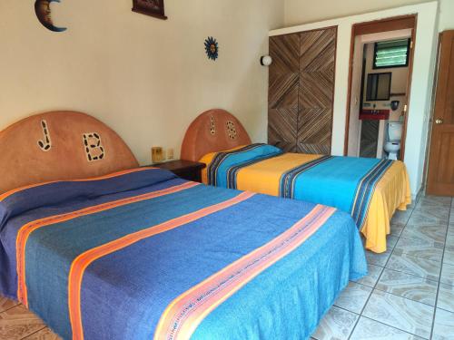 a hotel room with two beds in a room at Hotel J.B. in Zihuatanejo