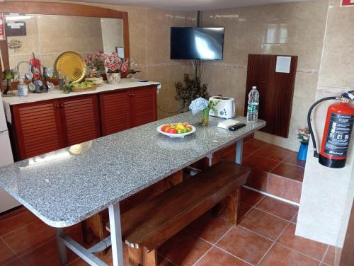 a kitchen with a table with a bowl of fruit on it at AL Miradouro do Outeiro in Guarda