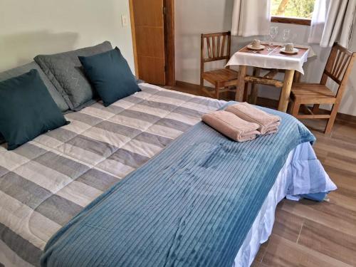 a bedroom with a large bed with two towels on it at Chalé dois irmãos in Visconde De Maua