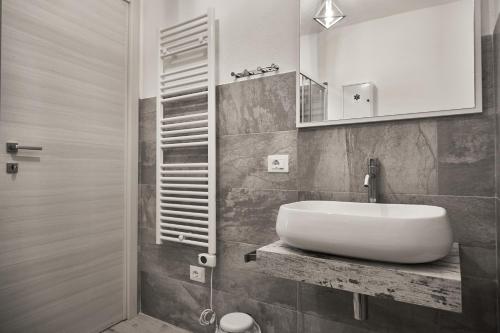 a bathroom with a white sink and a mirror at Eureka Room & Breakfast in Pietrapertosa