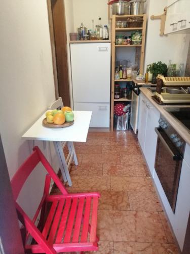 eine Küche mit roten Stühlen und einem Tisch mit Obst darauf in der Unterkunft In the Heart of Salzburg in Salzburg