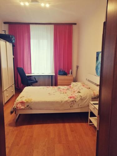 Schlafzimmer mit einem Bett und einem Fenster mit rosa Vorhängen in der Unterkunft In the Heart of Salzburg in Salzburg
