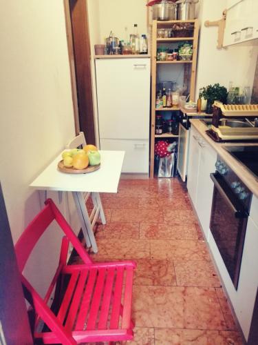 a kitchen with a table and two red chairs at In the Heart of Salzburg in Salzburg