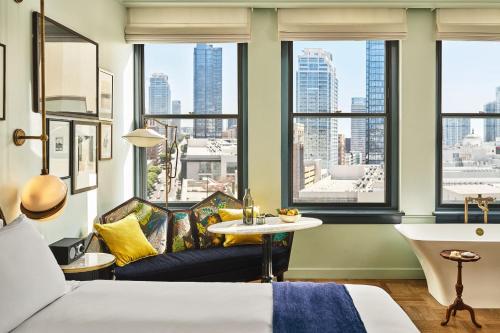 a hotel room with a bed and a table and windows at Hotel Per La, Autograph Collection in Los Angeles