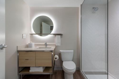 a bathroom with a toilet and a sink and a mirror at TownePlace Suites by Marriott Canfield in Canfield