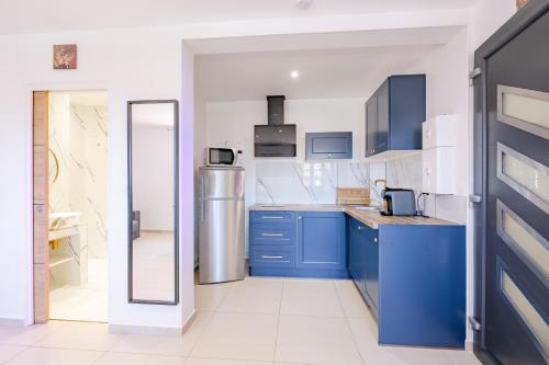 a kitchen with blue cabinets and a refrigerator at Free Sun Appart in Fréjus