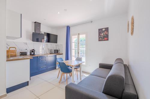 a living room with a couch and a table and a kitchen at Free Sun Appart in Fréjus