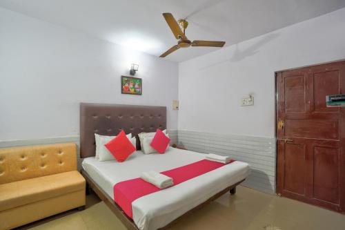 a bedroom with a bed and a couch and a ceiling fan at Dolphin service apptment in Calangute