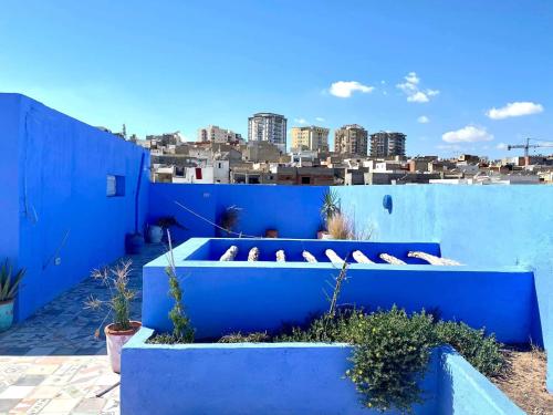 a blue house with blue walls and plants at Dar Lekbira Boutique Hôtel in Sousse