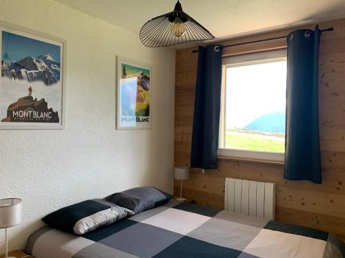 1 dormitorio con cama y ventana grande en Samoens 1600, ski au pied, en Samoëns