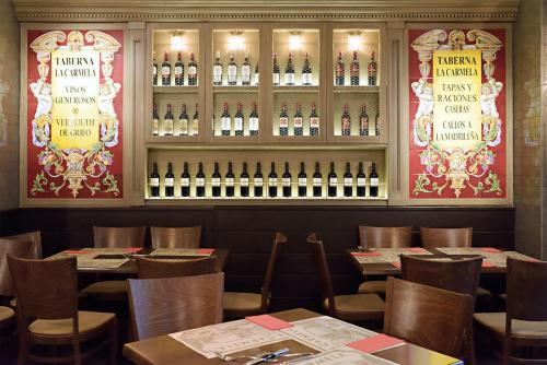 a dining room with tables and bottles of wine at Victoria 4 Puerta del Sol in Madrid