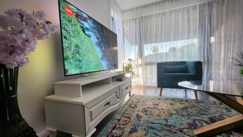 a living room with a flat screen tv on a dresser at Conacul Alb, prilej de vacanță 