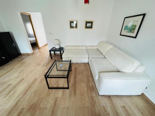 un soggiorno con divano bianco e tavolo di Casa Quiteria a La Aljorra