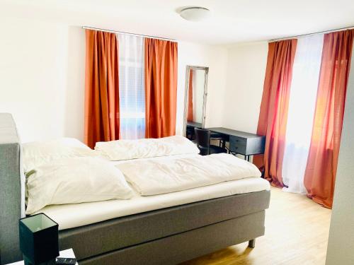 a bedroom with a bed and a desk and curtains at Hotel SuvaNa 