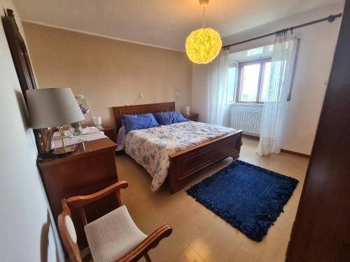 a bedroom with a bed and a chair and a window at Nonna Dorina Casa Vacanze in Pietrabbondante