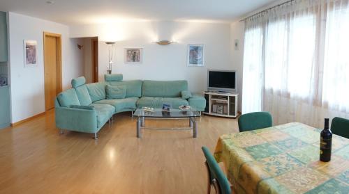 a living room with a blue couch and a table at Haus Alpsägu, Bettmeralp in Bettmeralp