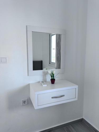 a white bathroom with a white dresser and a mirror at Sevilia Rooms in Qeparo