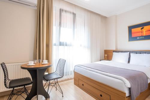 Un dormitorio con una cama y una mesa y sillas. en Campus Boutique Hotel, en Estambul