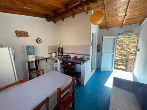 a small kitchen with a table and a refrigerator at La Casa del Rey de las Ballenas in Puerto Pirámides