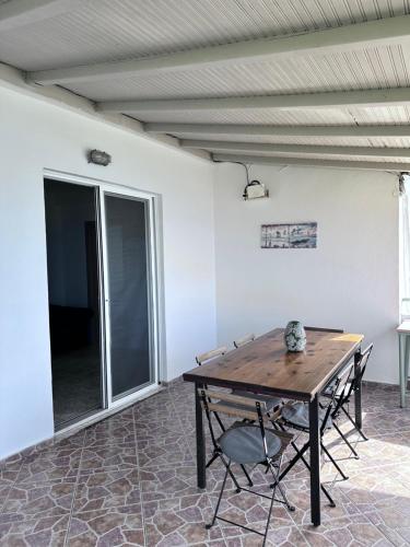 a room with a wooden table and two chairs at Sevilia Rooms in Qeparo