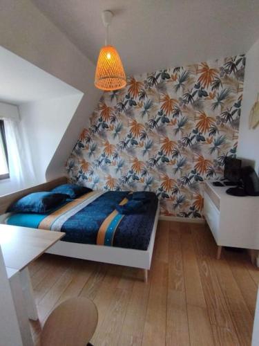 - une chambre avec un lit, une table et une chaise dans l'établissement Le ptit nid de Louviers TV/Fibre, à Louviers