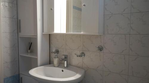a bathroom with a white sink and a mirror at Urban Blue House in Agios Nikolaos