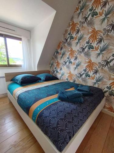 - une chambre avec un lit doté d'oreillers bleus dans l'établissement Le ptit nid de Louviers TV/Fibre, à Louviers