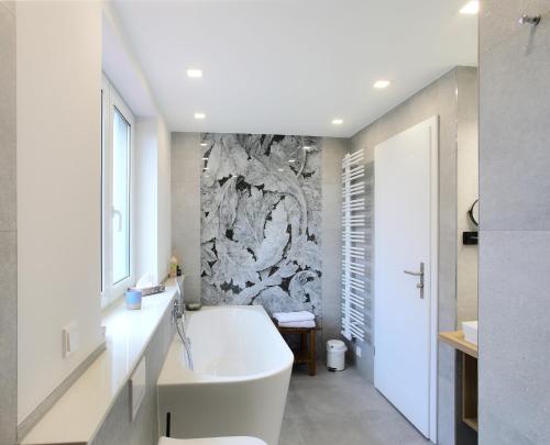 a bathroom with a white tub and a stone wall at Haus Welzel in Dresden