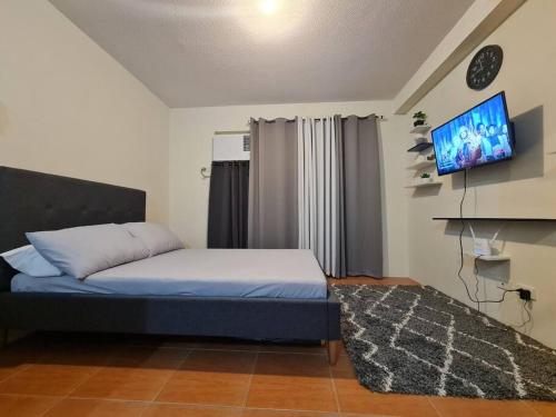 1 dormitorio con 1 cama y TV de pantalla plana en Cebu One Oasis Fully Furnished Studio with balcony, en Carreta