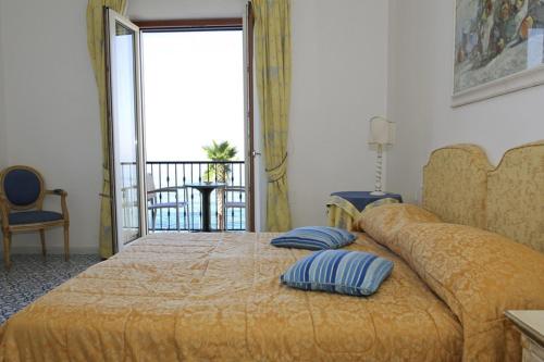 una camera da letto con un grande letto con due cuscini sopra di Hotel Villa Sirio a Santa Maria di Castellabate