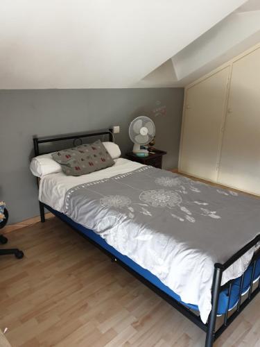 - une chambre avec un lit et une couette grise et blanche dans l'établissement chambre parentale avec douche et wc, à Lourdes