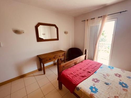 a bedroom with a bed and a mirror and a window at Apartamento T2 equipado Vila Verde in Santa Maria