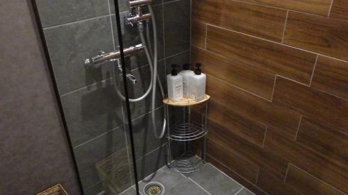 a bathroom with a shower with two soap bottles at 日月庵 BnB Sunmoon in Kanazawa