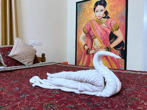 un cisne en una cama con una foto de una mujer en Aryavilla Heritage, en Varkala