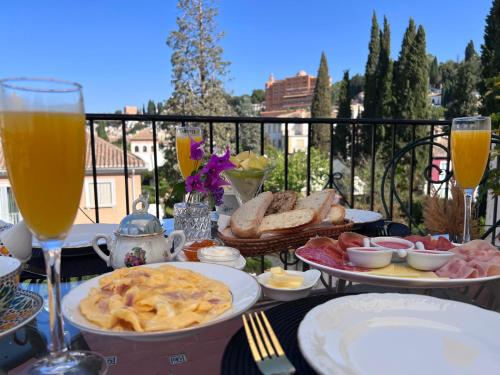 una mesa con platos de comida y vasos de zumo de naranja en Hotelito Suecia, en Granada