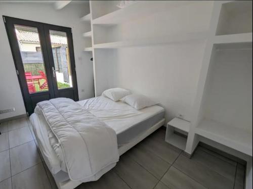 un lit blanc dans une chambre avec une fenêtre dans l'établissement Maison indépendante 35m² classée proche d'Ylium., à Olonne-sur-Mer