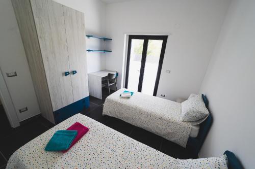Zimmer mit 2 Betten und einem roten Objekt oben in der Unterkunft BLU OCEANO (Casa Vacanza) in Guardialfiera