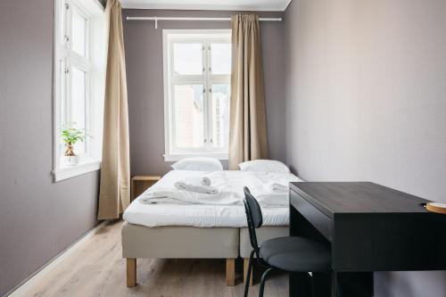 a bedroom with a bed and a desk and a window at S54 - Private Rooms in the City Center in Bergen