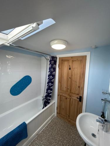a bathroom with a tub and a toilet and a sink at See the llamas at a beautiful Somerset Cottage in Combe Saint Nicholas