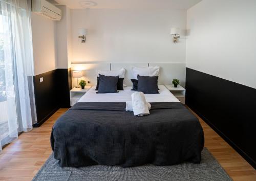 a bedroom with a large bed with blue and white pillows at Hôtel Gallia Cannes in Cannes