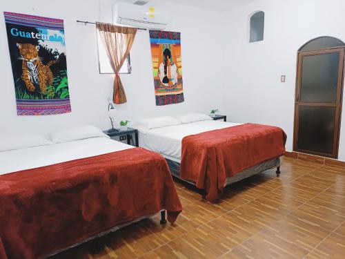 a room with two beds with red sheets at Casa Diversa in Esquipulas