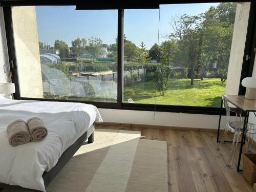 une chambre avec un lit et une grande fenêtre dans l'établissement Villa Wine & Roses, à Libourne