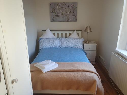 Schlafzimmer mit einem Bett mit blauer Decke in der Unterkunft Patricia’s Country Cottage in Sligo
