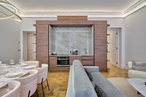une salle à manger avec une table et des chaises blanches dans l'établissement Apartment Matignon by Studio prestige, à Paris
