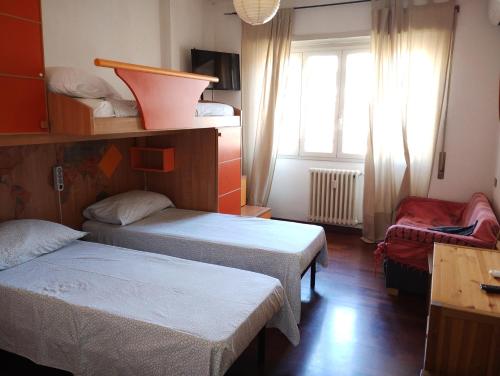 Habitación pequeña con 2 camas y ventana en Checchi House, en Roma